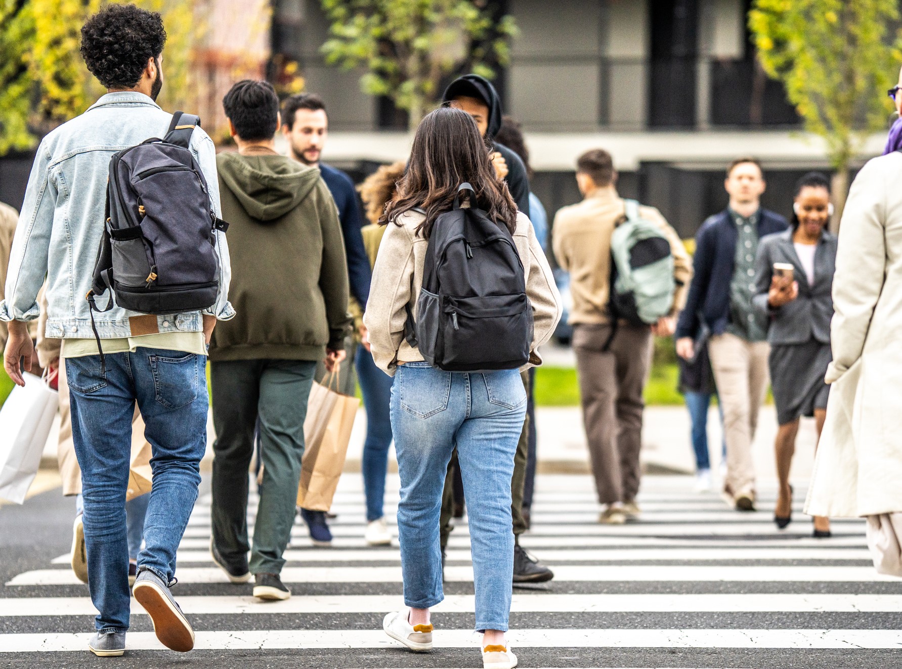 Men and women walking across busy road crosswalk