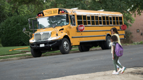 School Bus Crossing Safety: School bus with parent and child crossing street